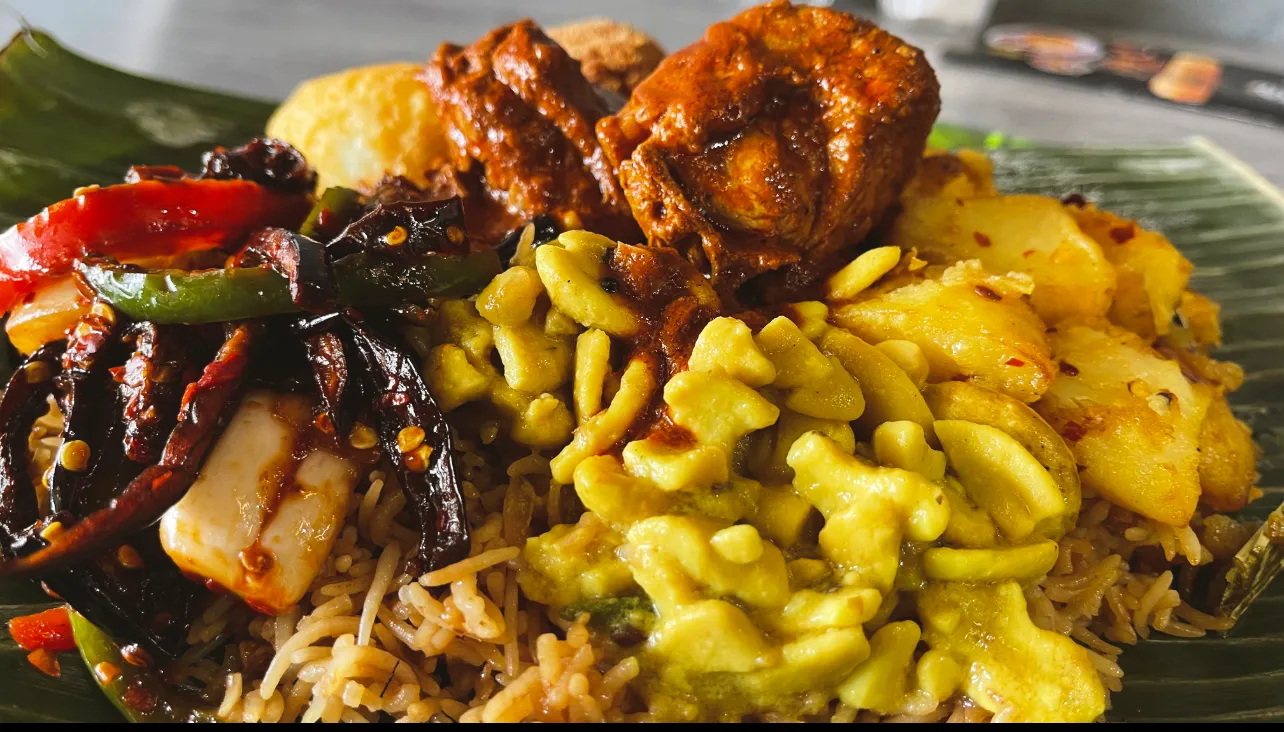 Biryani on banana leaf with glazed chicken, potato, lentil sprouts and chilli stir-fry